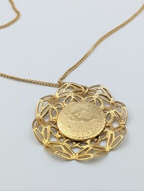 Aquarius gold tone open metal work round pendant necklace